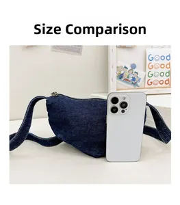 Detailed comparison of the blue denim half-moon bag size with a smartphone for scale