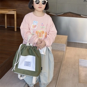 Olive green drawstring backpack for kids with front pocket and contrast white straps