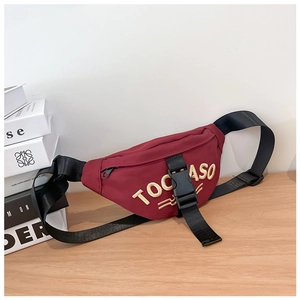 Detail of red canvas kids waist bag with TOCASO embroidery and adjustable black strap