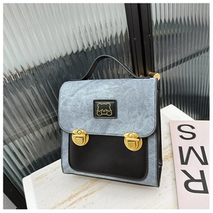 Detail shot of vintage denim patchwork bag with golden bear logo and dual push-locks