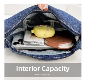 Internal view of denim crossbody bag showing storage capacity for phone and accessories