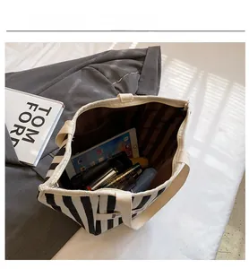 Detail showing the large capacity of a striped canvas kids bag with a secure zipper closure