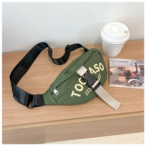 Detail of army green canvas waist bag for kids with embroidered TOCASO letters on wood table