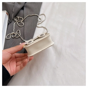 Détail du mini sac bandoulière crème avec chaîne serpent argentée et boucles métal