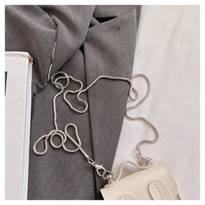 Vue détaillée d'un mini sac enfant crème avec chaîne serpent argentée et couture fine