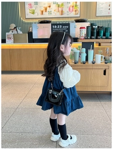 Détail du mini sac carré élégant en cuir verni noir avec boucle en argent sur une fille