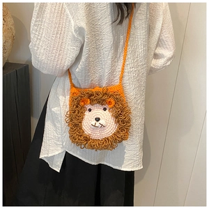 Détail d'un sac bandoulière lion crocheté à la main porté par un enfant sur gris