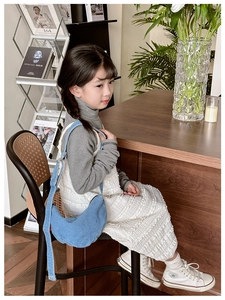 Detailed view of kids denim crescent crossbody bag with adjustable strap in casual setting
