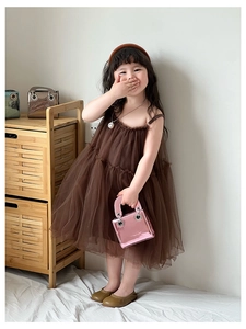 Détail du sac à bandoulière en cuir verni rose brillant avec robe tutu en tulle marron