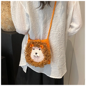 Détail du sac bandoulière lion en tricot orange fait main montrant la texture des mailles