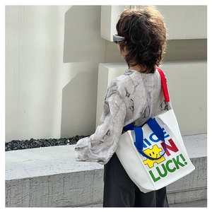 Détail du sac fourre-tout en toile avec imprimé NICE LUCK et anses contrastées
