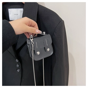 Détail du mini sac bandoulière noir avec coutures blanches contrastées et chaîne argentée