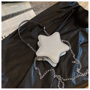 Détail du sac bandoulière argenté pailleté en forme d'étoile avec chaîne et texte embossé