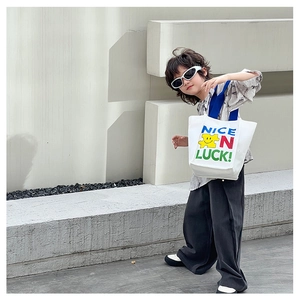 Détail du sac fourre-tout en toile blanche pour enfants avec bandoulière bleue