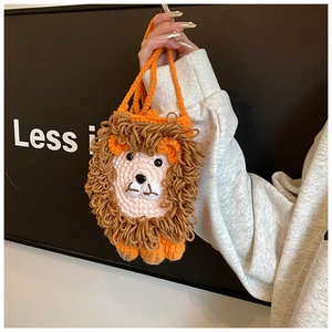 Détail d'un petit sac bandoulière lion en tricot fait main pour enfant en fil orange