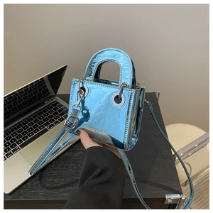 Détail du mini sac bandoulière en cuir verni bleu avec lettrage doré et poignée en métal