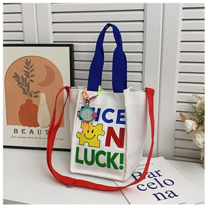 Détail du sac fourre-tout blanc en toile avec smiley jaune et breloque raquette