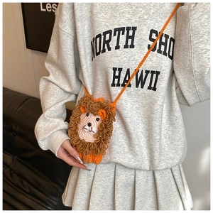 Détail d'un sac bandoulière lion en crochet fait main en fil orange avec crinière bouclée brune