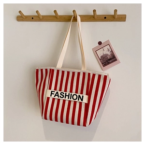 Detail showing red and white striped canvas tote bag with FASHION letter strap detail