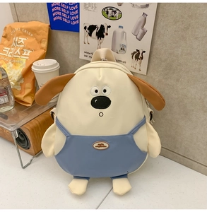Dettaglio dello zaino a cucciolo con design a salopette blu e orecchie in peluche