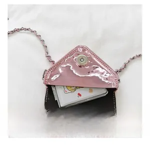 Detail view of pink mirror-finish mini bag interior with silver chain and magnetic snap