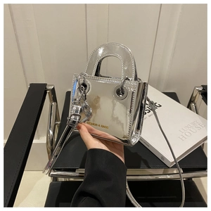 Détail d'un mini sac à main argenté effet miroir avec œillets métalliques et texte fashion