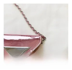 Close-up of the detachable metal chain hook on a pink triangle crossbody bag for kids