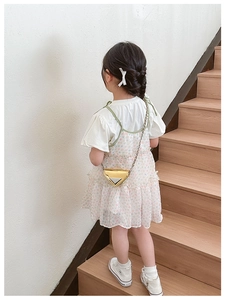Detail of metallic gold triangle kids crossbody bag with shiny chain and silver logo plate