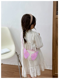 Detail of pink butterfly wing crossbody bag with sequins on child model back
