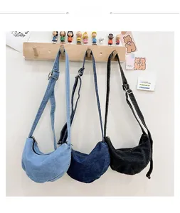Detailed view of denim dumpling bags in light blue, dark blue and black colors