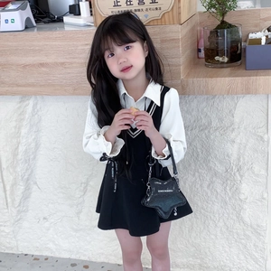 Tenue mode fille avec chemise blanche, robe pull noire et sac bandoulière étoile pailleté