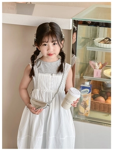Silver triangle chain mini bag styled with a white lace dress in a cozy cafe setting