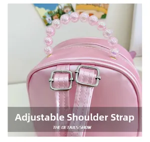 Detail of adjustable shoulder straps and iridescent bead handle on pink backpack