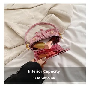 Detail showing the internal capacity of the pink metallic saddle bag with lipstick