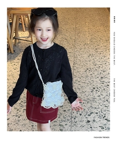 Détail d'un sac seau enfant en satin blanc avec filet de perles et bandoulière chic