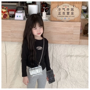 Girl wearing a stylish silver glitter crossbody bag with metallic chain strap detail