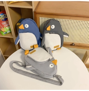 Detailansicht der Pinguin-Brusttaschen aus Nylon in Blau, Dunkelgrau und Hellgrau