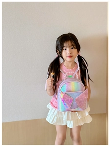 Detail of glitter girl backpack with 3D wings and elegant pearl handle accessory