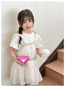 Detail of pink laser triangle mini chain bag with metallic tag on toddler girl outfit