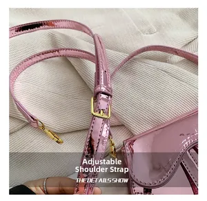 Detail of adjustable shoulder strap and gold hardware on pink laser finish saddle bag