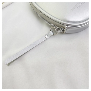 Primer plano del mini bolso plateado metálico con acabado en cuero y cremallera de metal