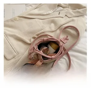 Vue intérieure du sac seau en paille rose montrant le rangement du maquillage quotidien