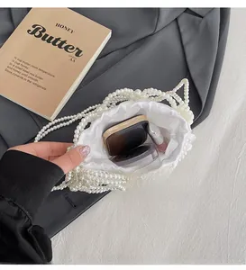 Détail du mini sac seau en perles avec doublure en satin et maquillage à l'intérieur