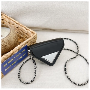 Detail shot of the glossy black patent leather mini triangle bag with metallic chain strap