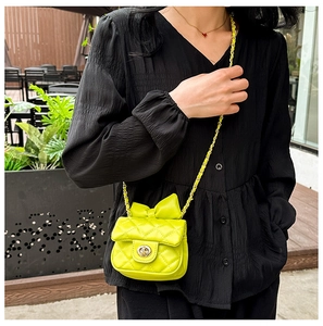 Neon green quilted mini bag for kids featuring a top bow and gold chain strap detail