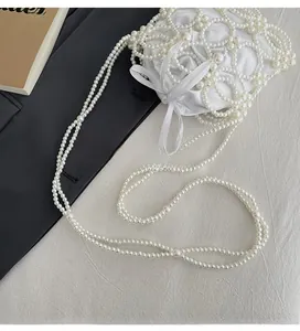 Vue de dessus d'un sac seau en perles blanches avec doublure satinée et nœud élégant
