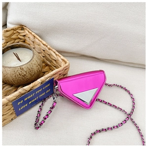 Macro detail of glossy metallic pink triangular bag with chain strap and silver emblem
