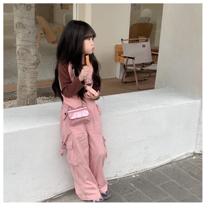 Detail of pink cargo overall and sparkling shoulder bag on a toddler girl outfit