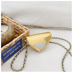 Close-up of a metallic gold triangle mini chain bag with a silver emblem detail