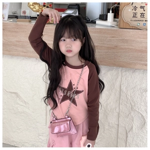 Close-up of pink sequined crossbody bag for kids with gold chain and star fashion tee